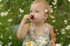 Девочка нюхает цветок